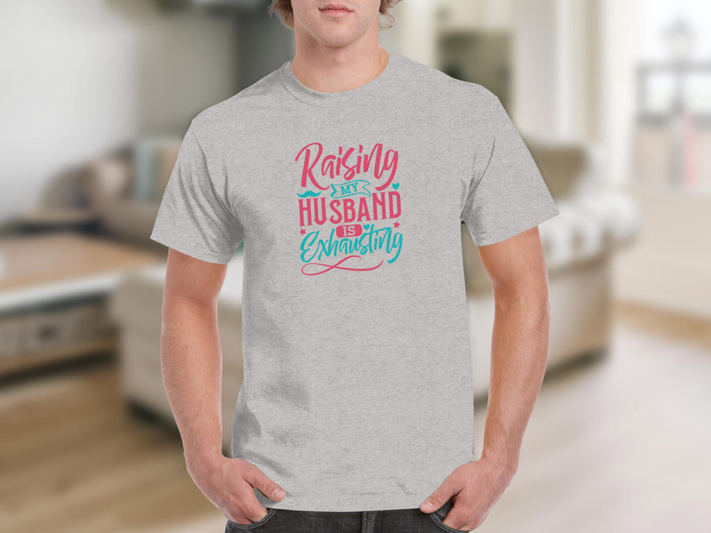Grey t-shirt with "Raising My Husband Is Exhausting" text and decorative accents.