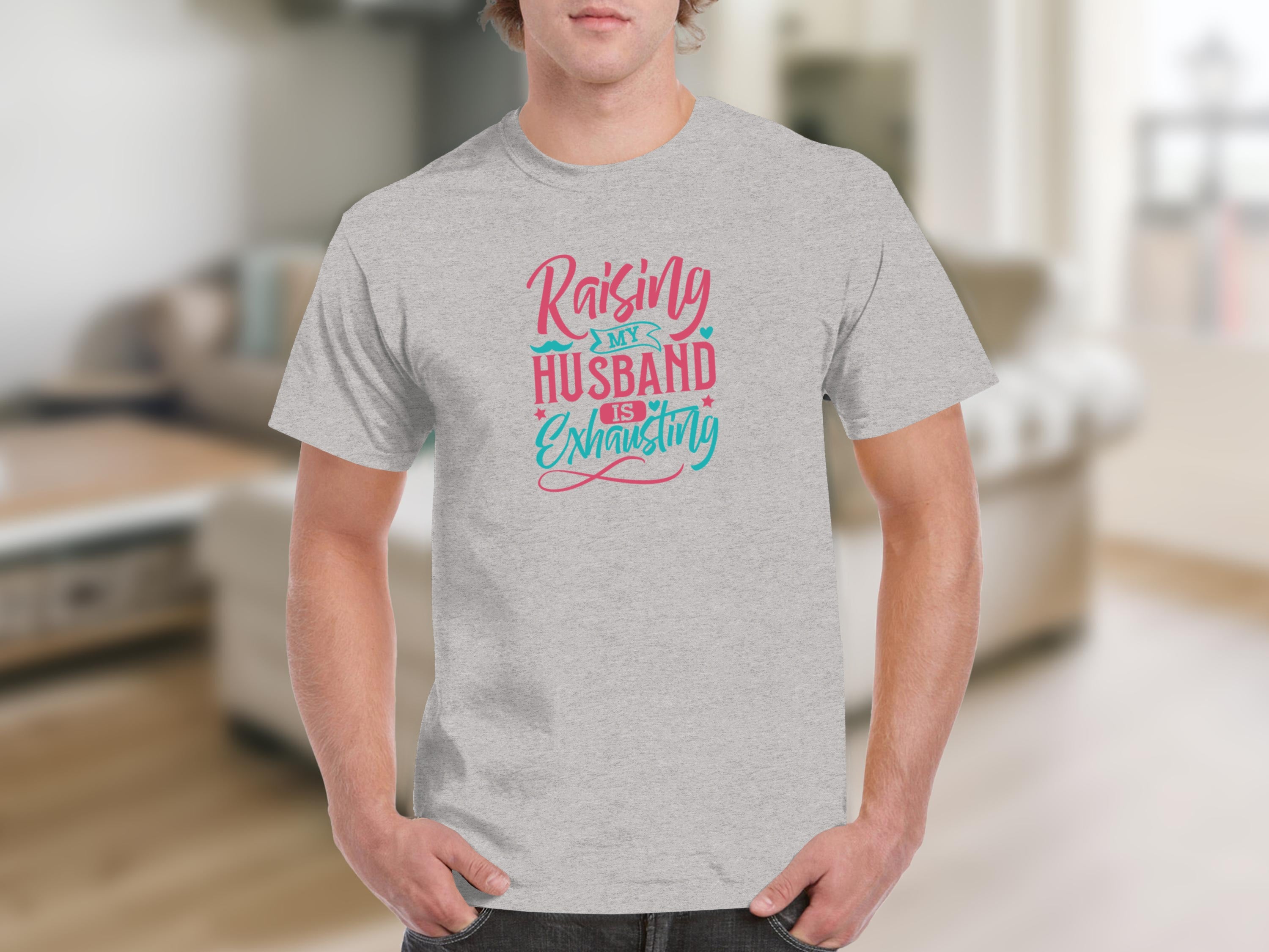 Grey t-shirt with "Raising My Husband Is Exhausting" text and decorative accents.