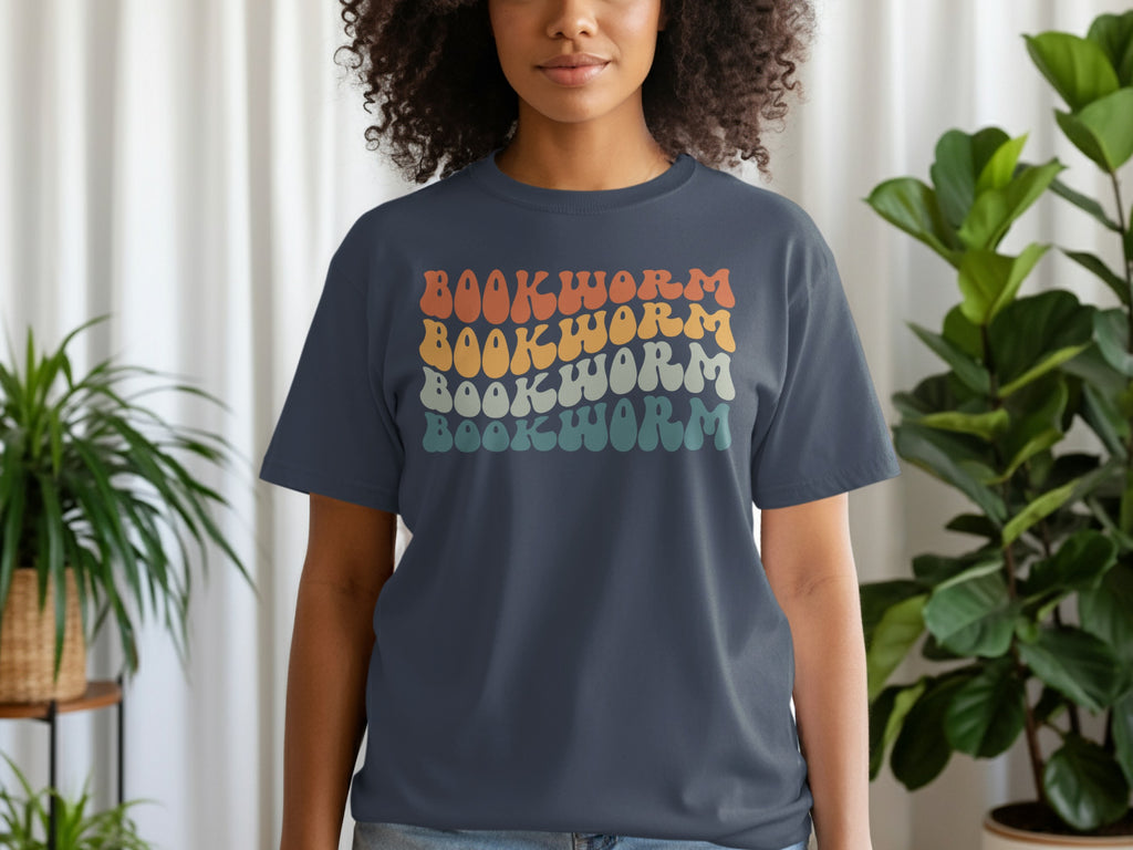 Dark blue t-shirt with repeating wavy text "BOOKWORM" in four retro color rows.
