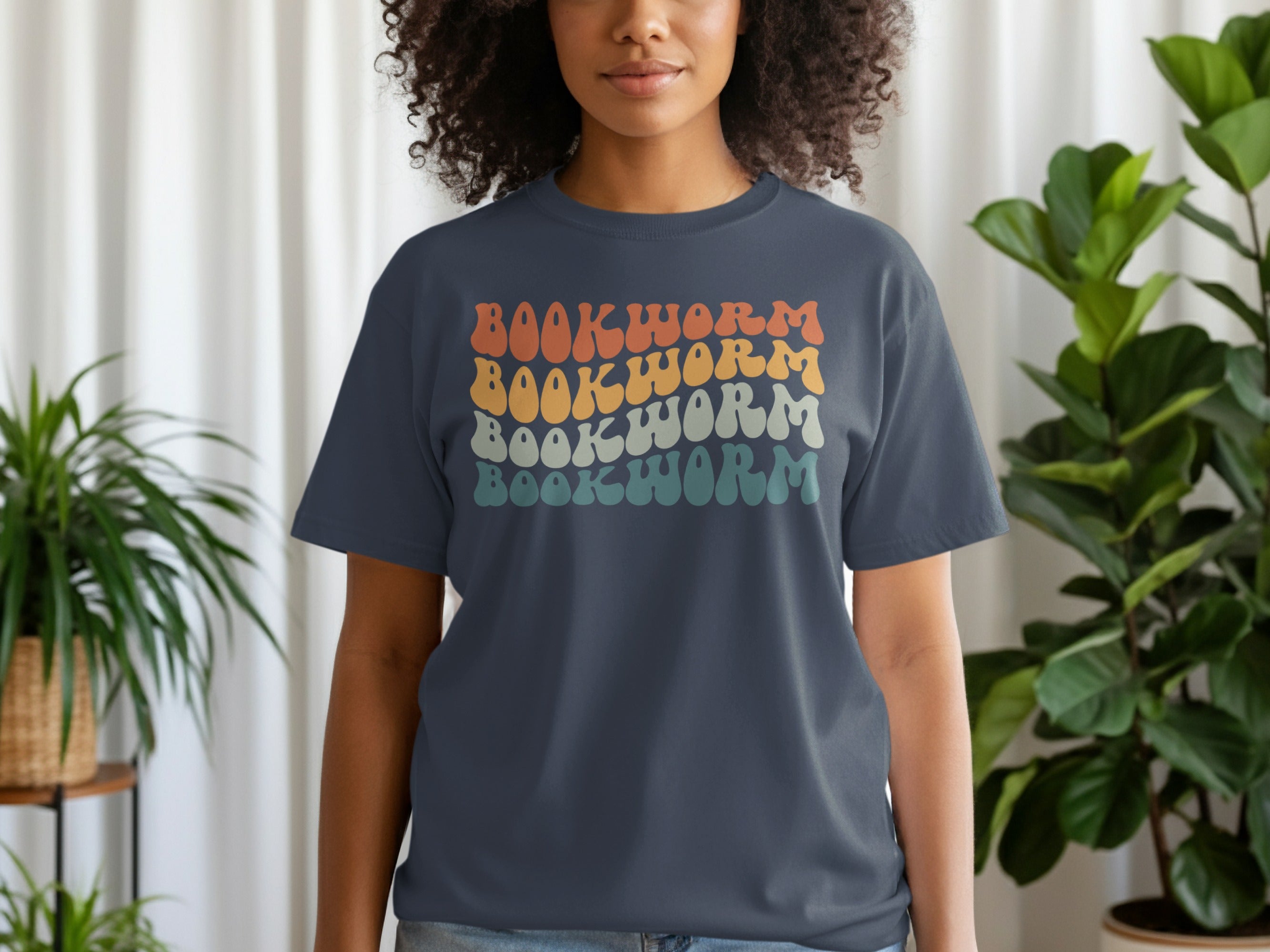Dark blue t-shirt with repeating wavy text "BOOKWORM" in four retro color rows.