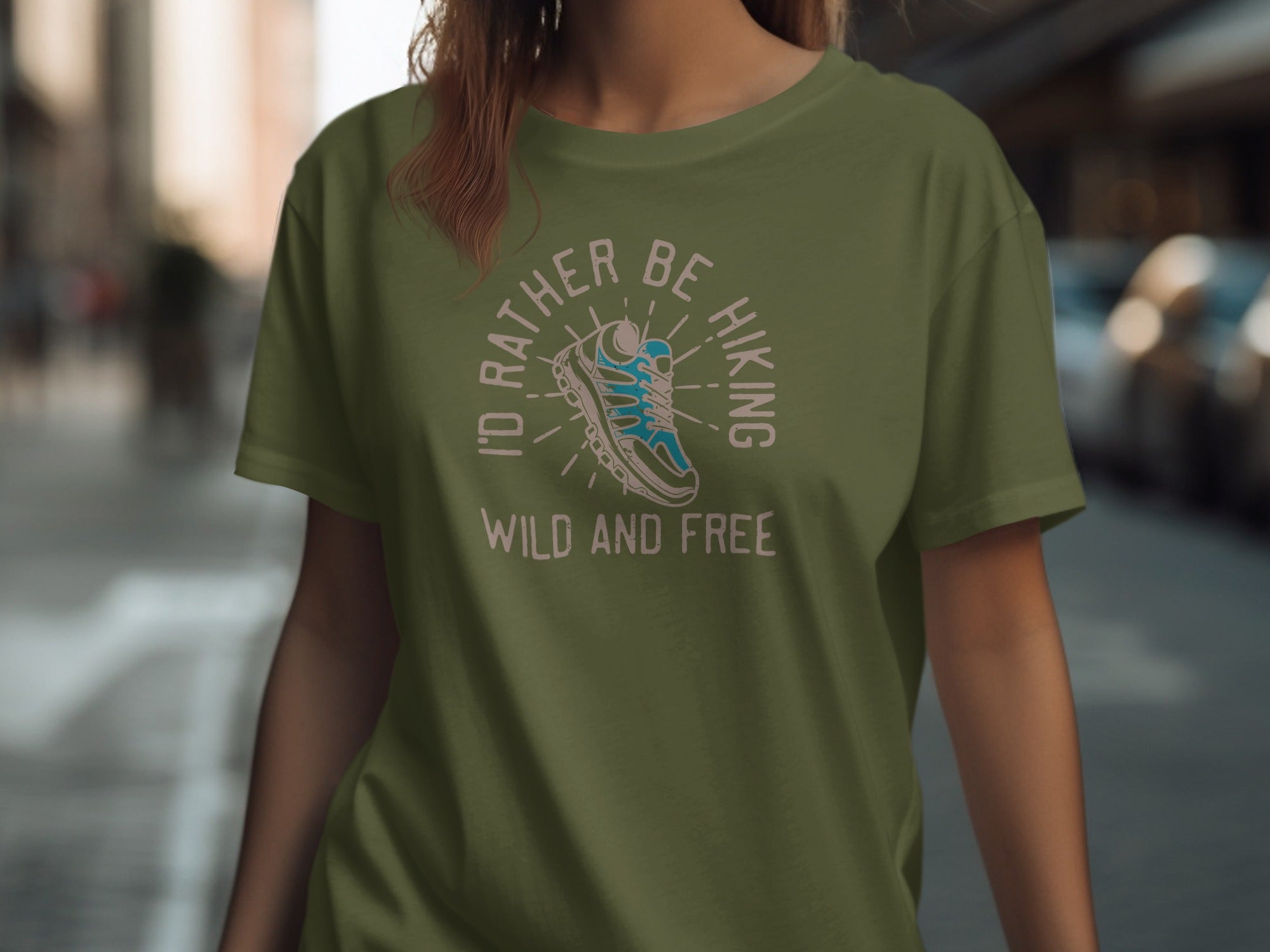 Olive green t-shirt with "I'd rather be hiking wild and free" text and shoe graphic.