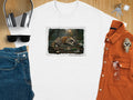 T-shirt graphic: raccoon asleep on park bench with bottles near a lamppost.