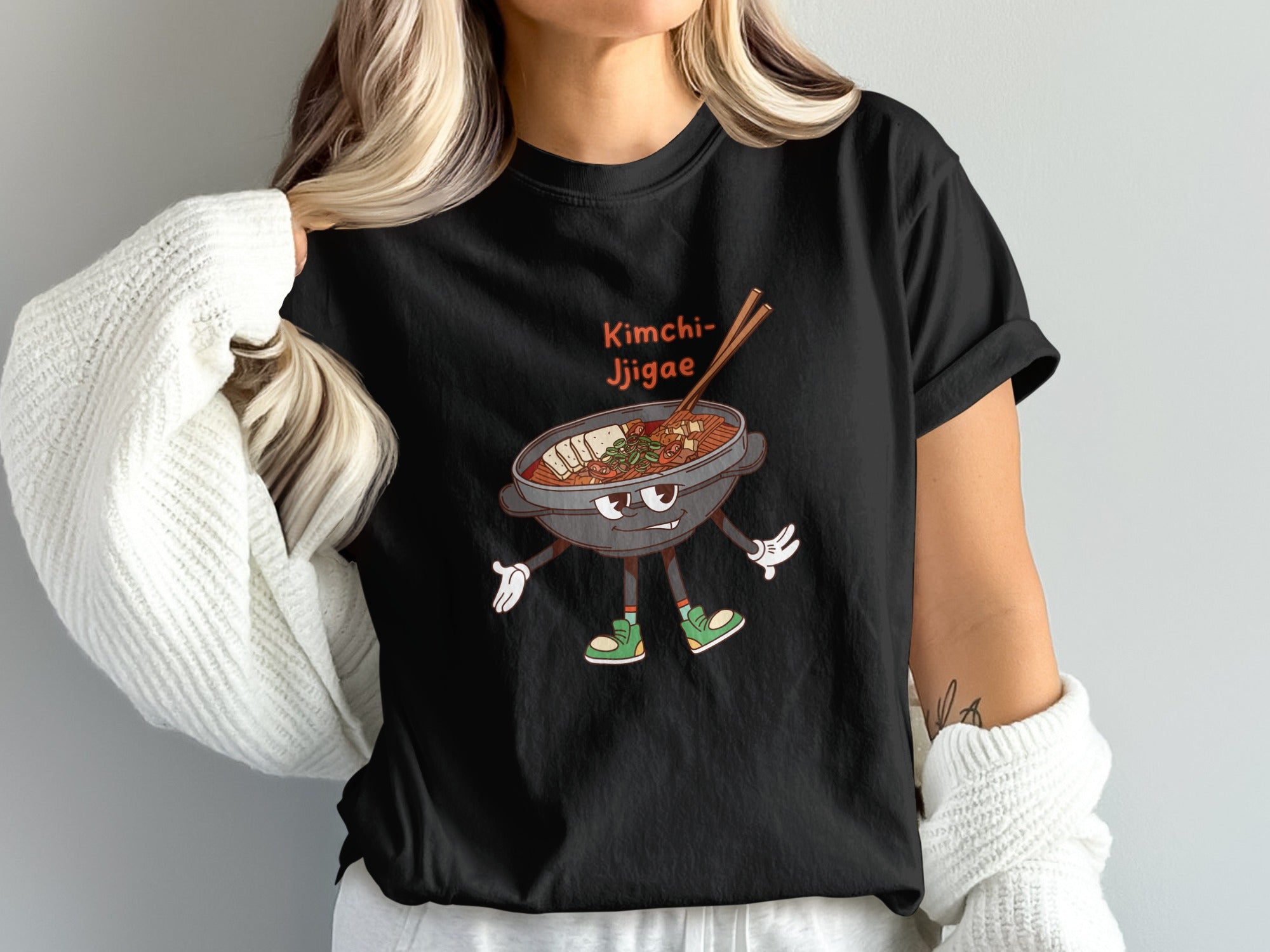 Black t-shirt with a cartoon of kimchi jjigae with arms and legs.