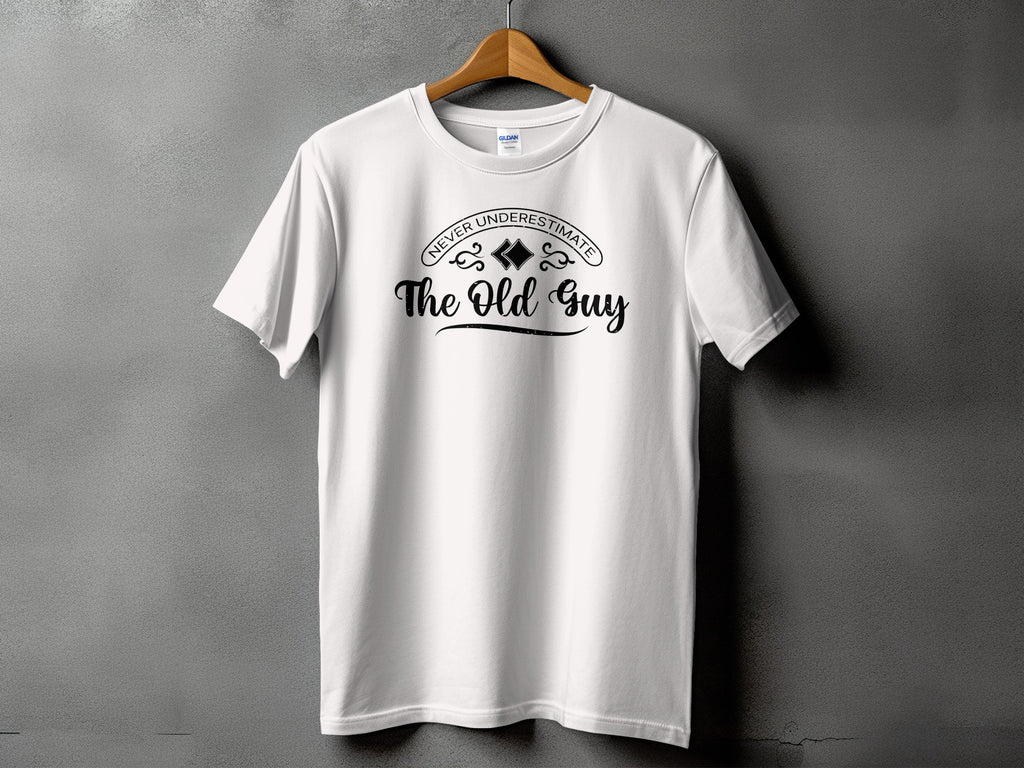 White t-shirt with black text "Never Underestimate The Old Guy".