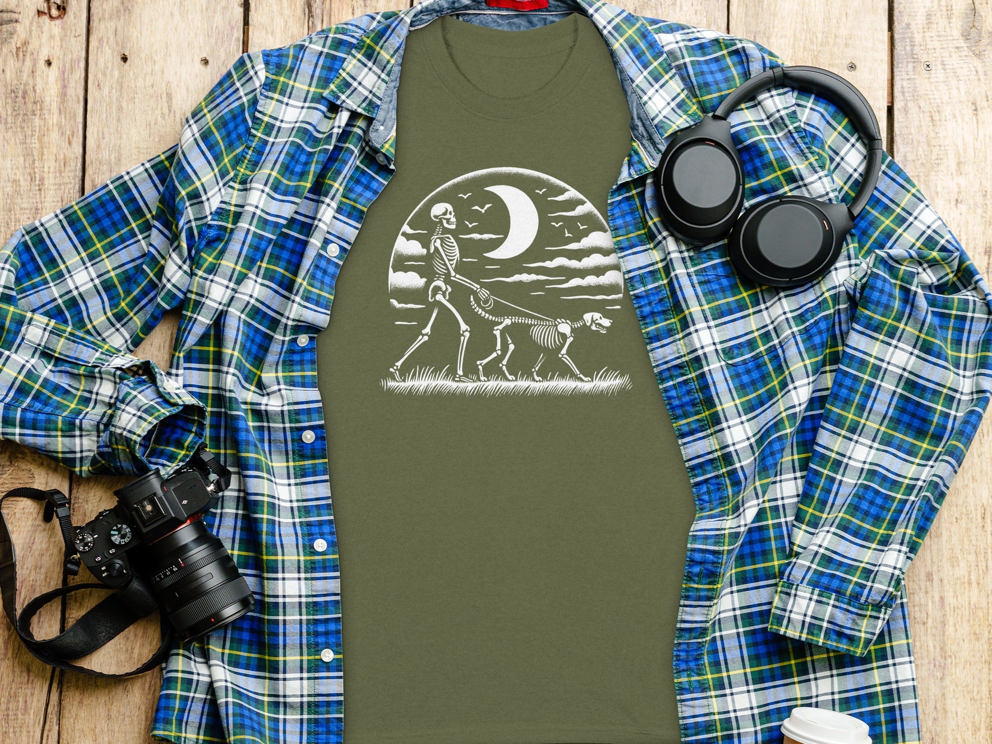 Green t-shirt with white skeleton walking dog graphic under moon.