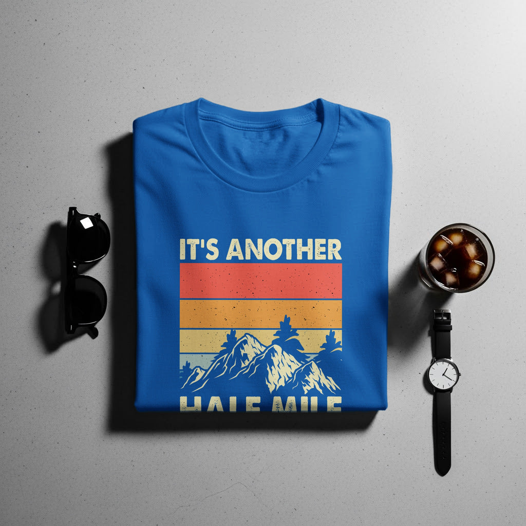 Blue t-shirt with "IT'S ANOTHER HALF MILE" text and mountain graphic.