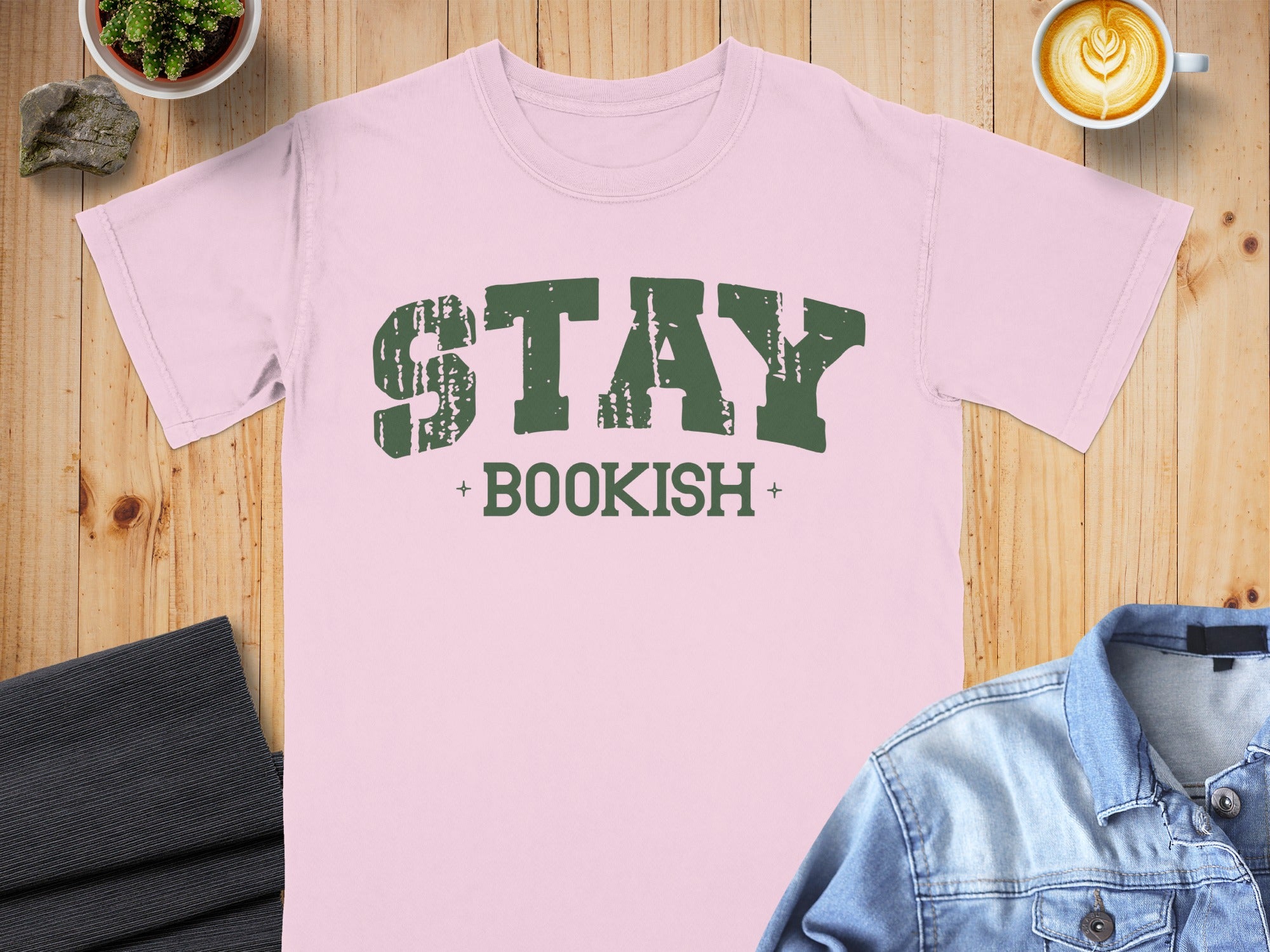 Pink t-shirt with distressed green text saying "STAY + BOOKISH +"