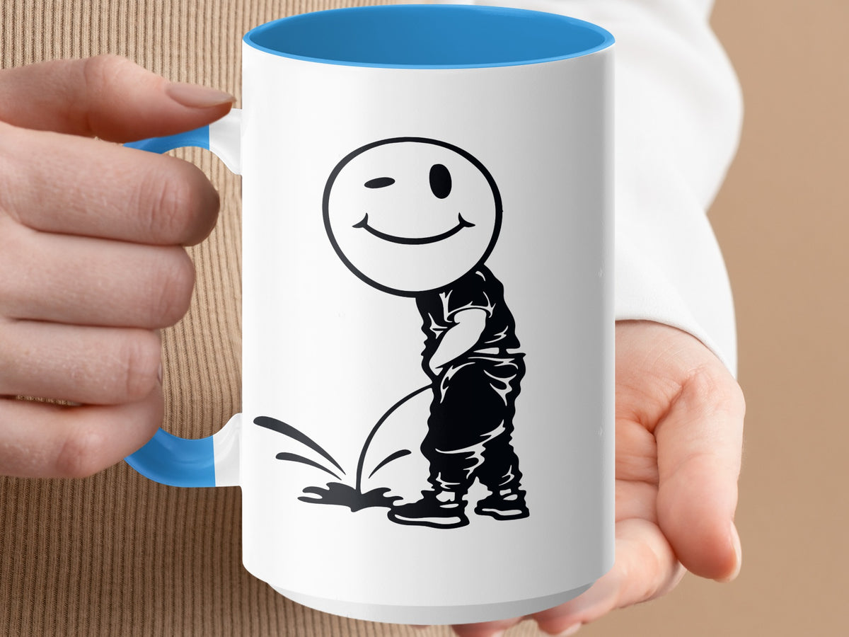 White mug with blue handle and interior, featuring a black graphic of a winking smiley face over a figure urinating.