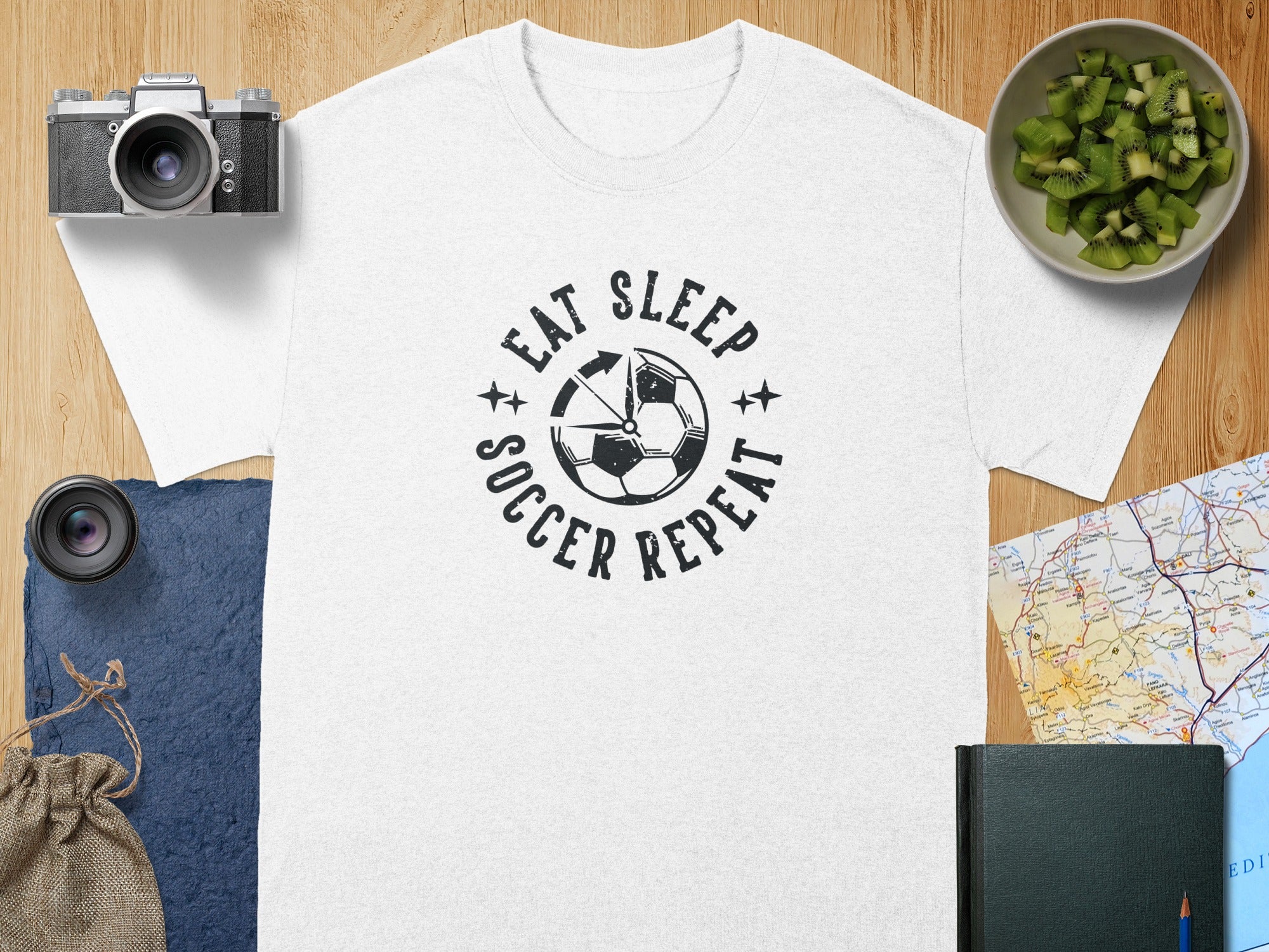 White t-shirt with "Eat Sleep Soccer Repeat" graphic and soccer ball design.