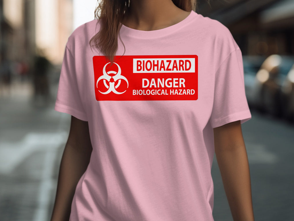 Pink t-shirt with white biohazard symbol and text "BIOHAZARD DANGER BIOLOGICAL HAZARD".