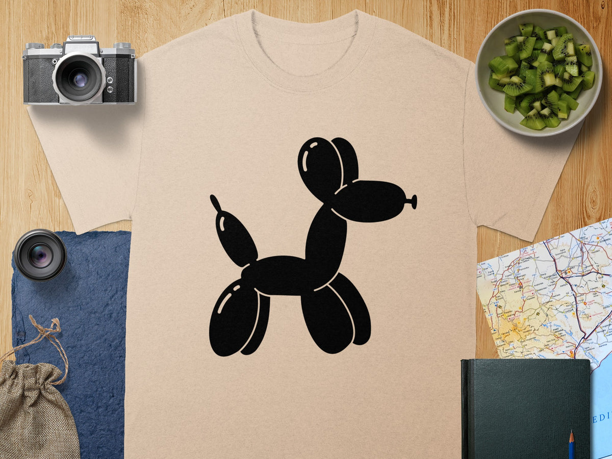 T-shirt with black balloon dog graphic, camera, kiwi, and map flat lay.
