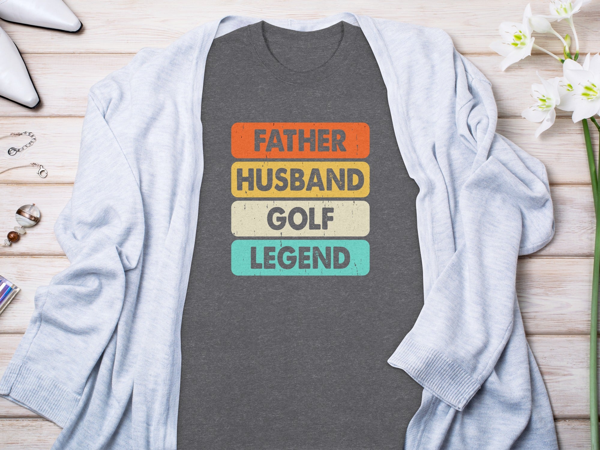 Dark gray t-shirt with text "Father Husband Golf Legend" in colored blocks.