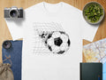 White t-shirt with a gritty black soccer ball breaking through a net graphic.
