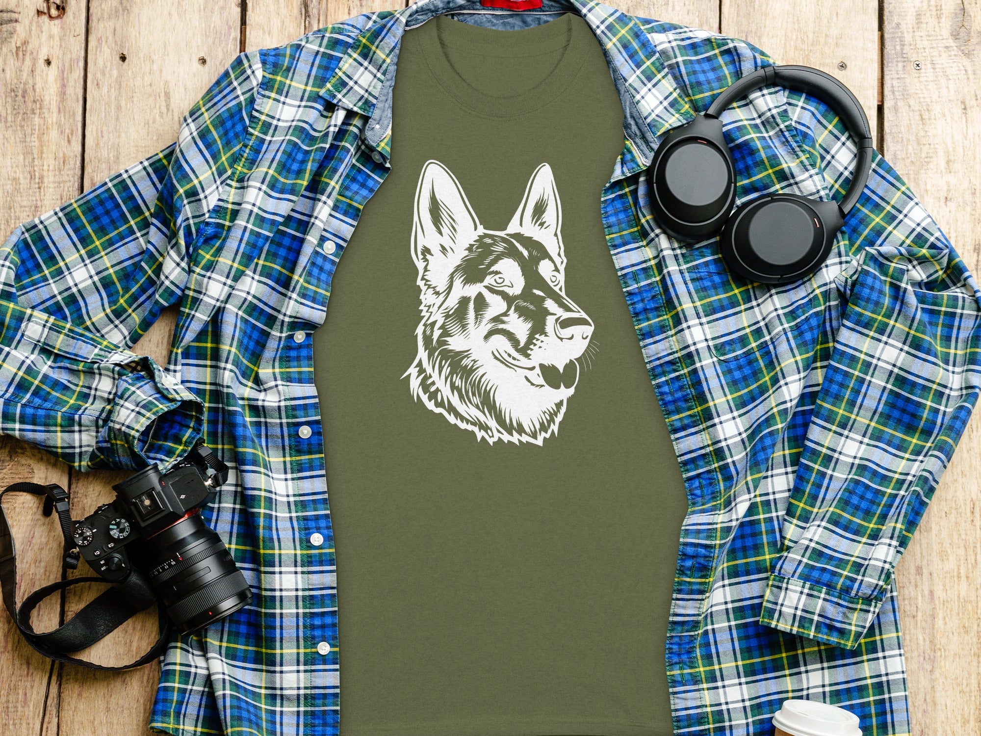 Olive t-shirt with white German Shepherd graphic, blue plaid shirt, headphones, and camera.