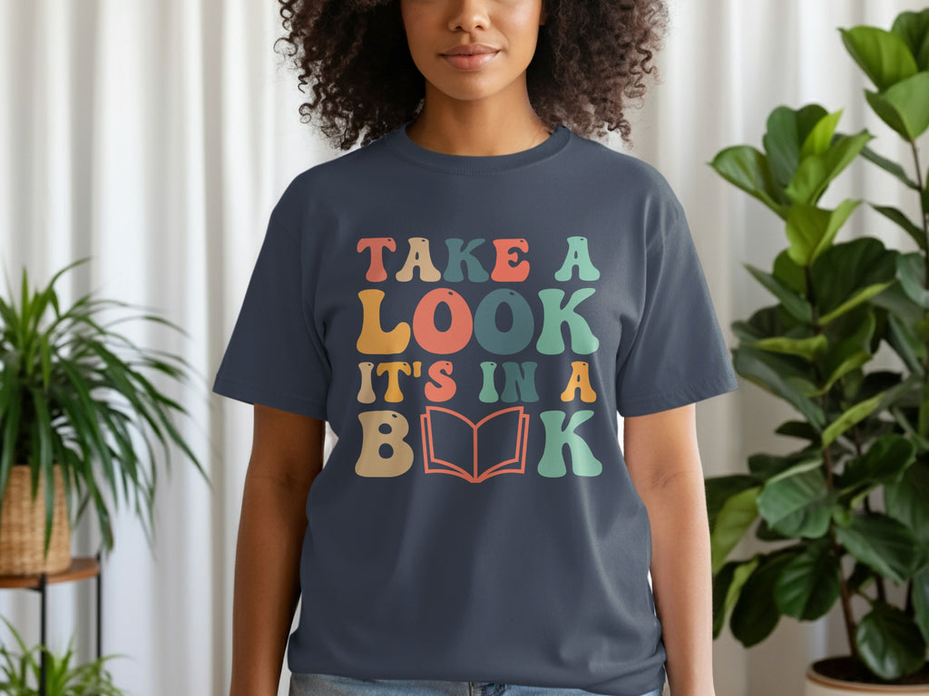 Dark blue t-shirt with text "Take a Look It's in a Book" and an open book graphic.