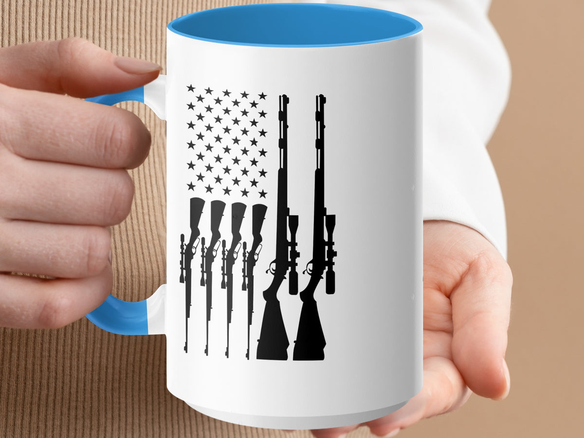 White mug with blue rim, featuring silhouette of American flag with rifles.