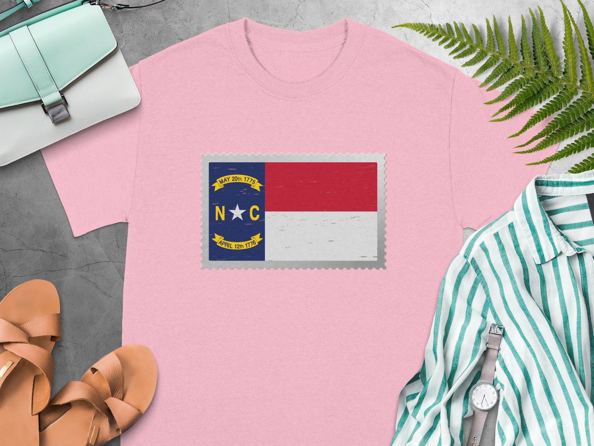 Pink t-shirt with North Carolina flag stamp graphic.