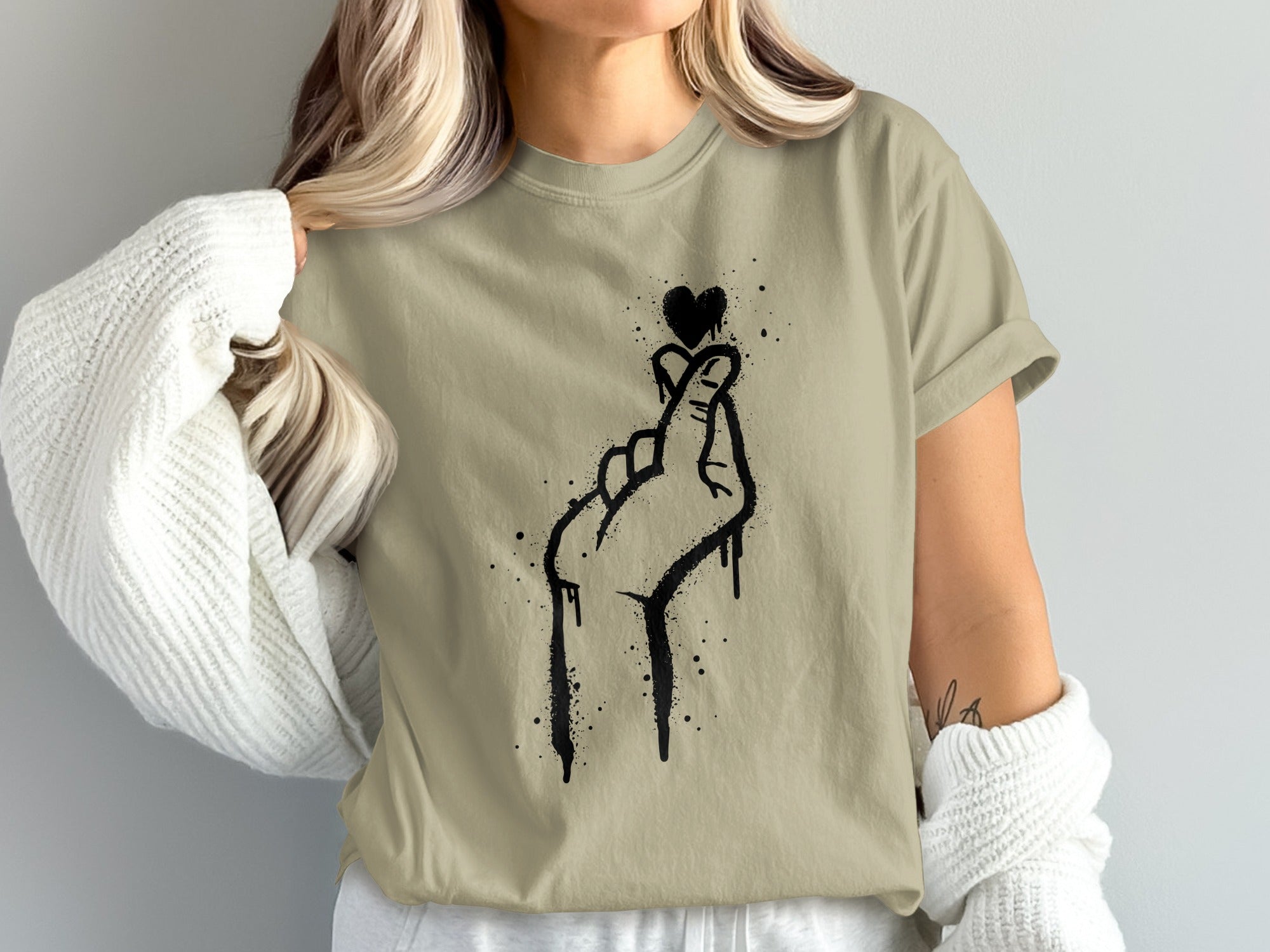 Khaki t-shirt with black graffiti-style hand and heart design.
