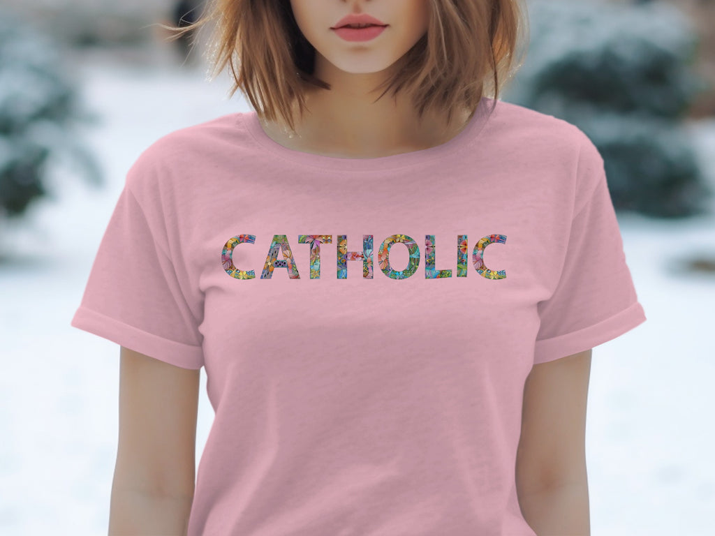 Pink t-shirt with "CATHOLIC" printed in colorful, intricate floral patterns.