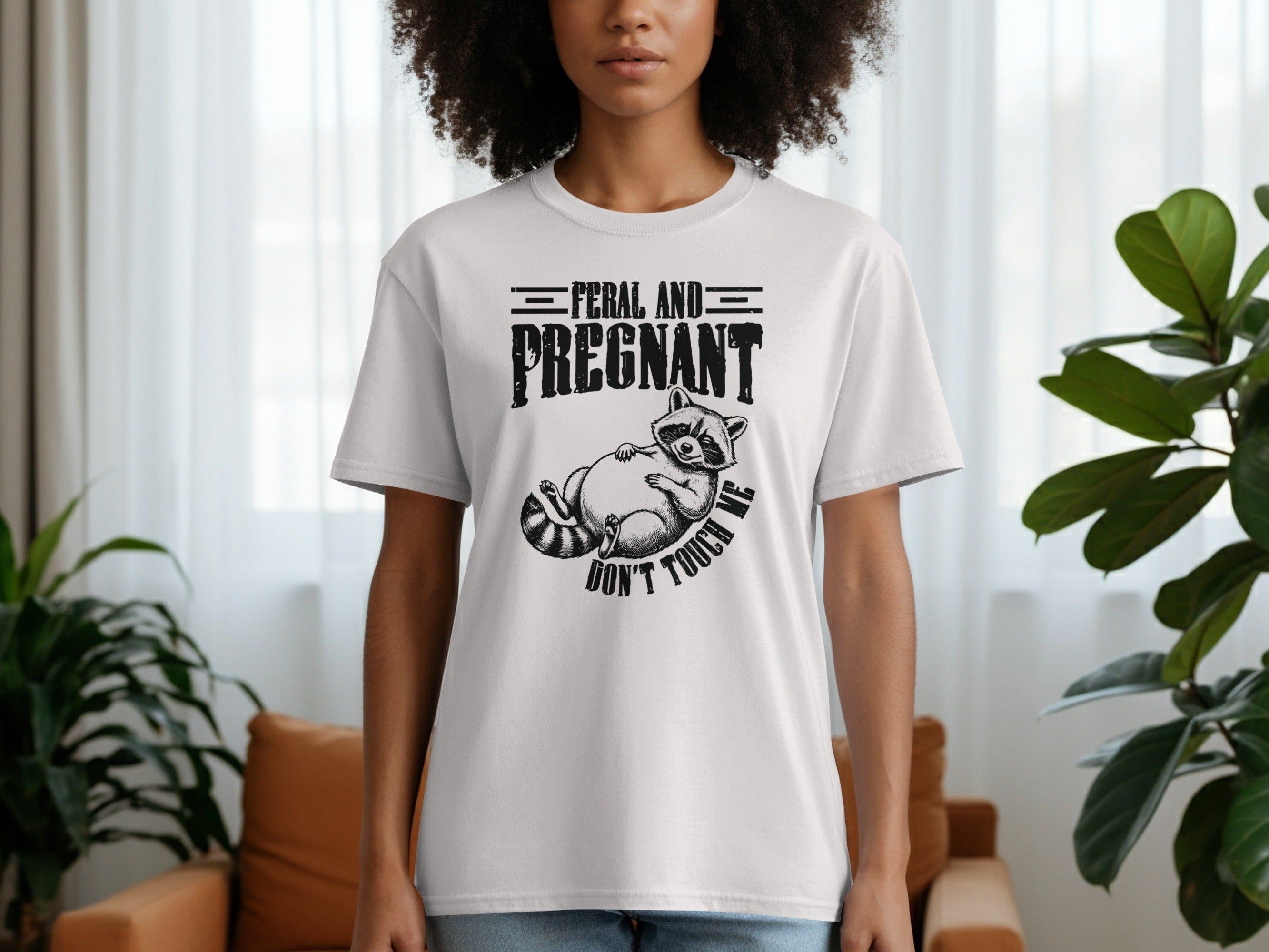 White t-shirt with graphic of raccoon and text "FERAL AND PREGNANT DON'T TOUCH ME"