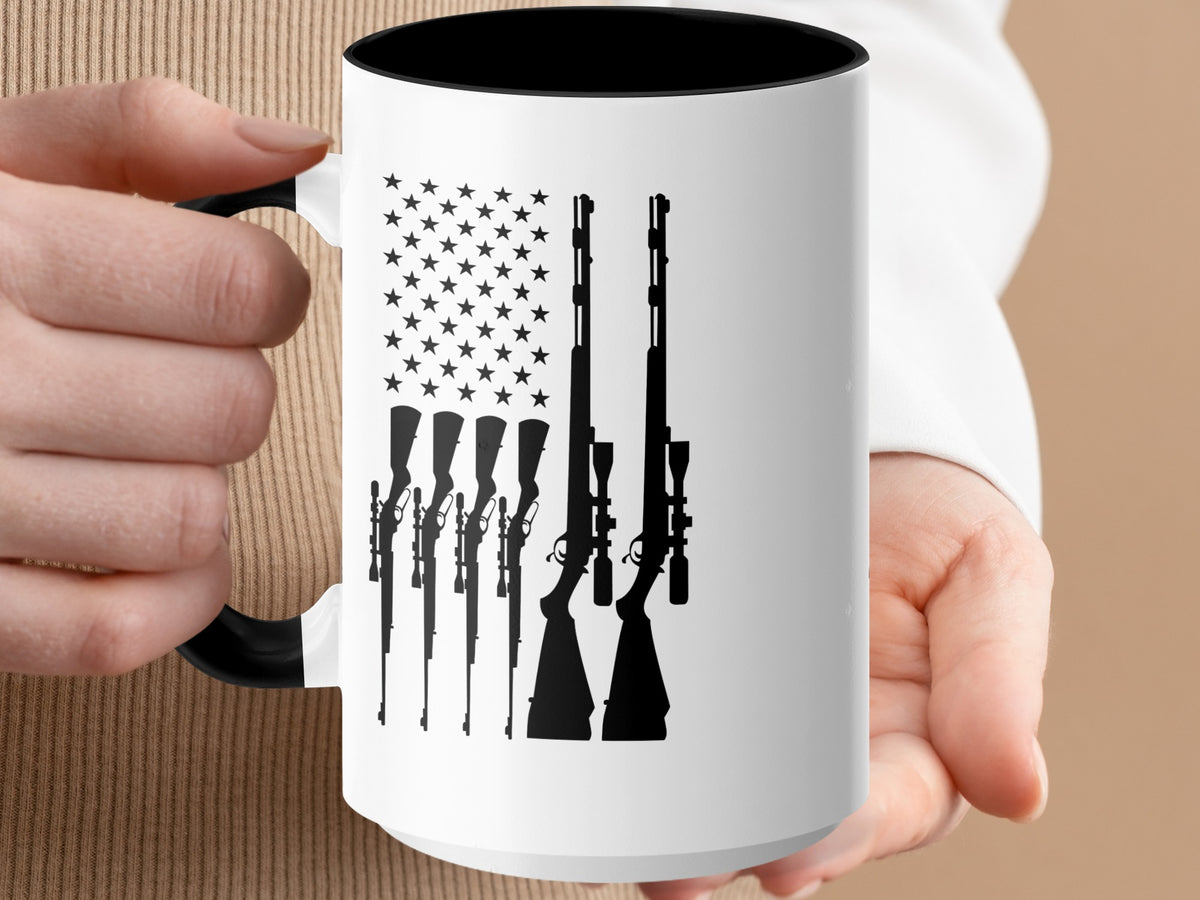 White mug with black rim and handle, featuring a US flag design with rifles.