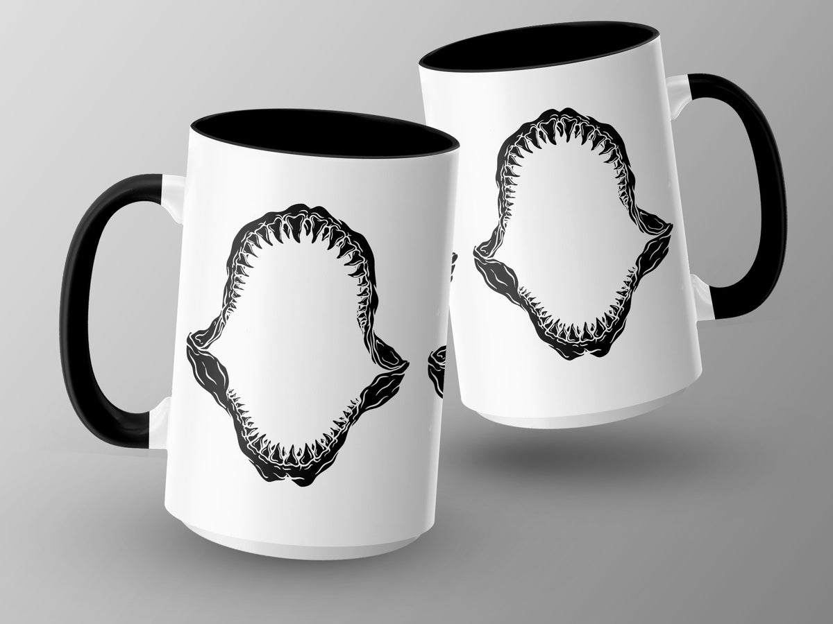 Two white mugs with black handles, each featuring a black graphic of shark teeth.