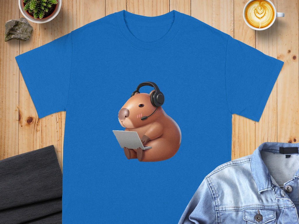 Blue t-shirt with cartoon capybara wearing headphones and using a laptop.