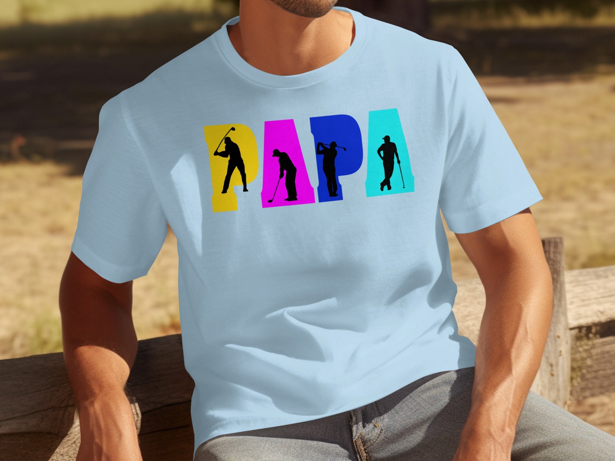 Light blue t-shirt with "PAPA" graphic featuring golfer silhouettes in colorful letter blocks.