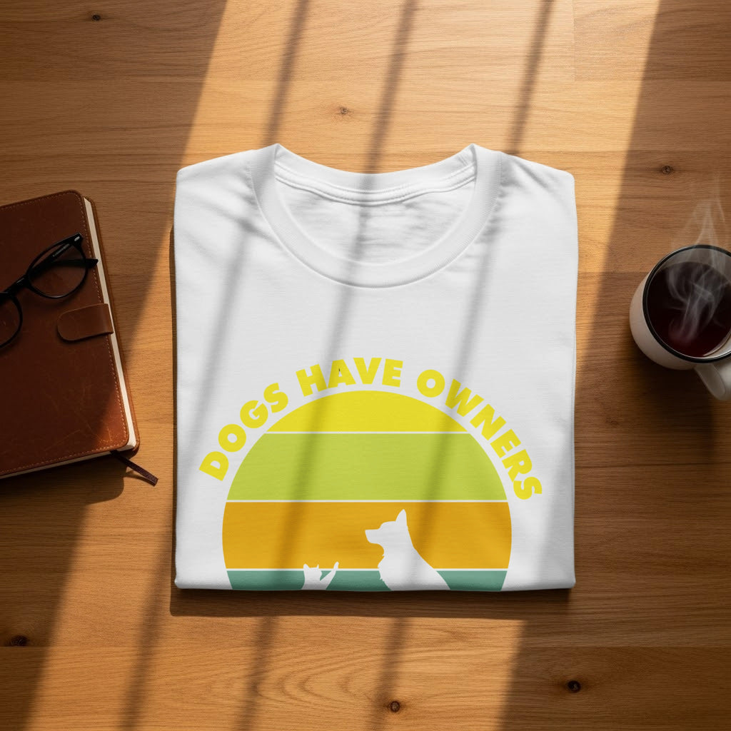 White t-shirt with yellow text "Dogs Have Owners" and dog and cat silhouettes.