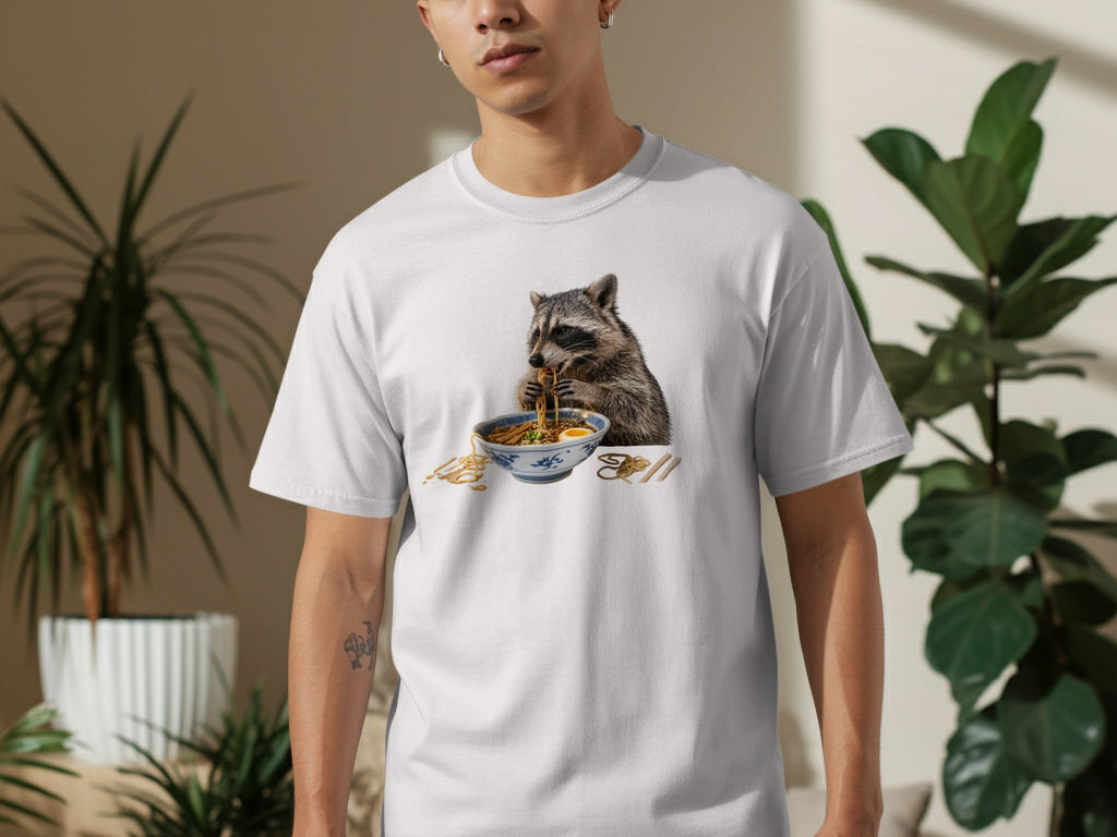 White t-shirt with a graphic of a raccoon eating ramen noodles from a blue and white bowl.
