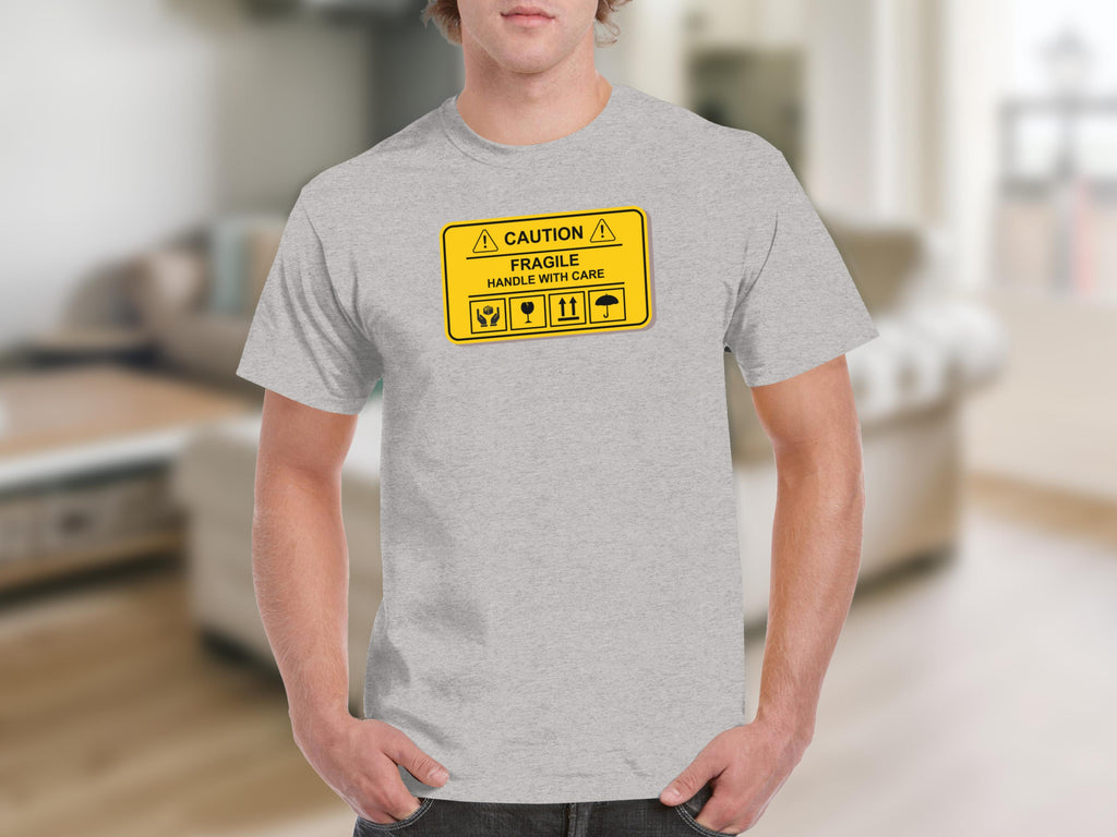 Grey t-shirt with "CAUTION FRAGILE HANDLE WITH CARE" shipping label graphic.