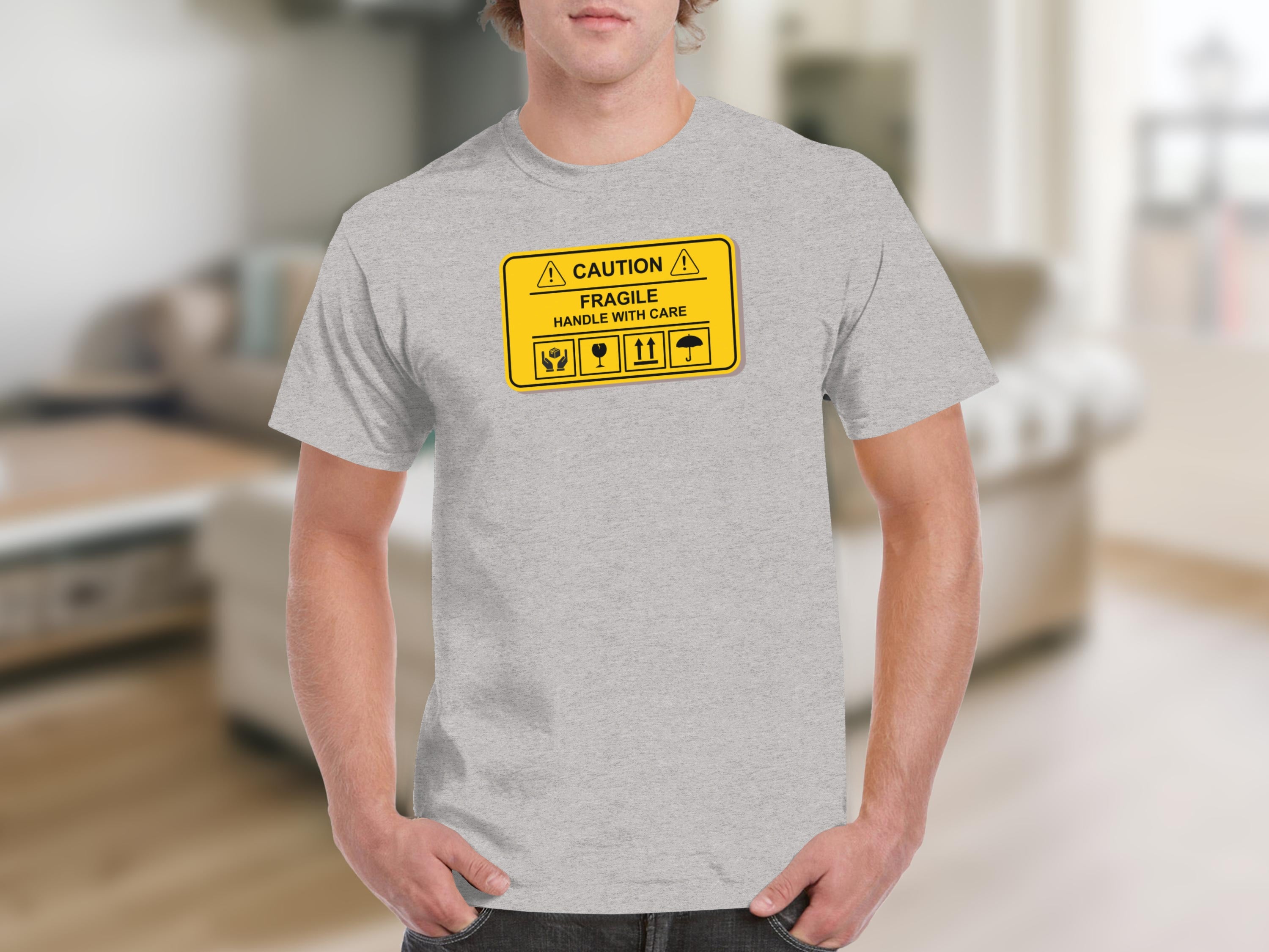 Grey t-shirt with "CAUTION FRAGILE HANDLE WITH CARE" shipping label graphic.