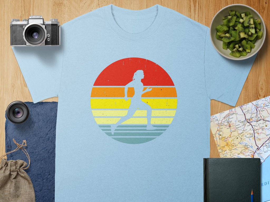 Light blue t-shirt with silhouette of a runner within a retro sunset graphic.