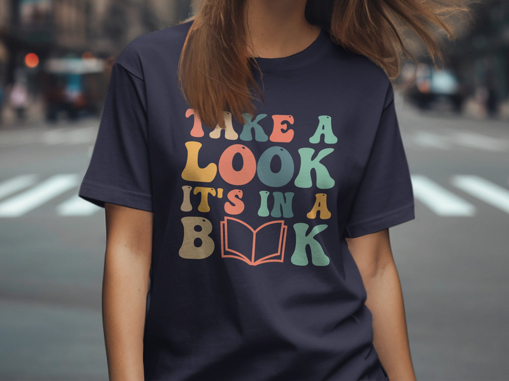 Navy t-shirt with text "TAKE A LOOK IT'S IN A BOOK" and an open book graphic.