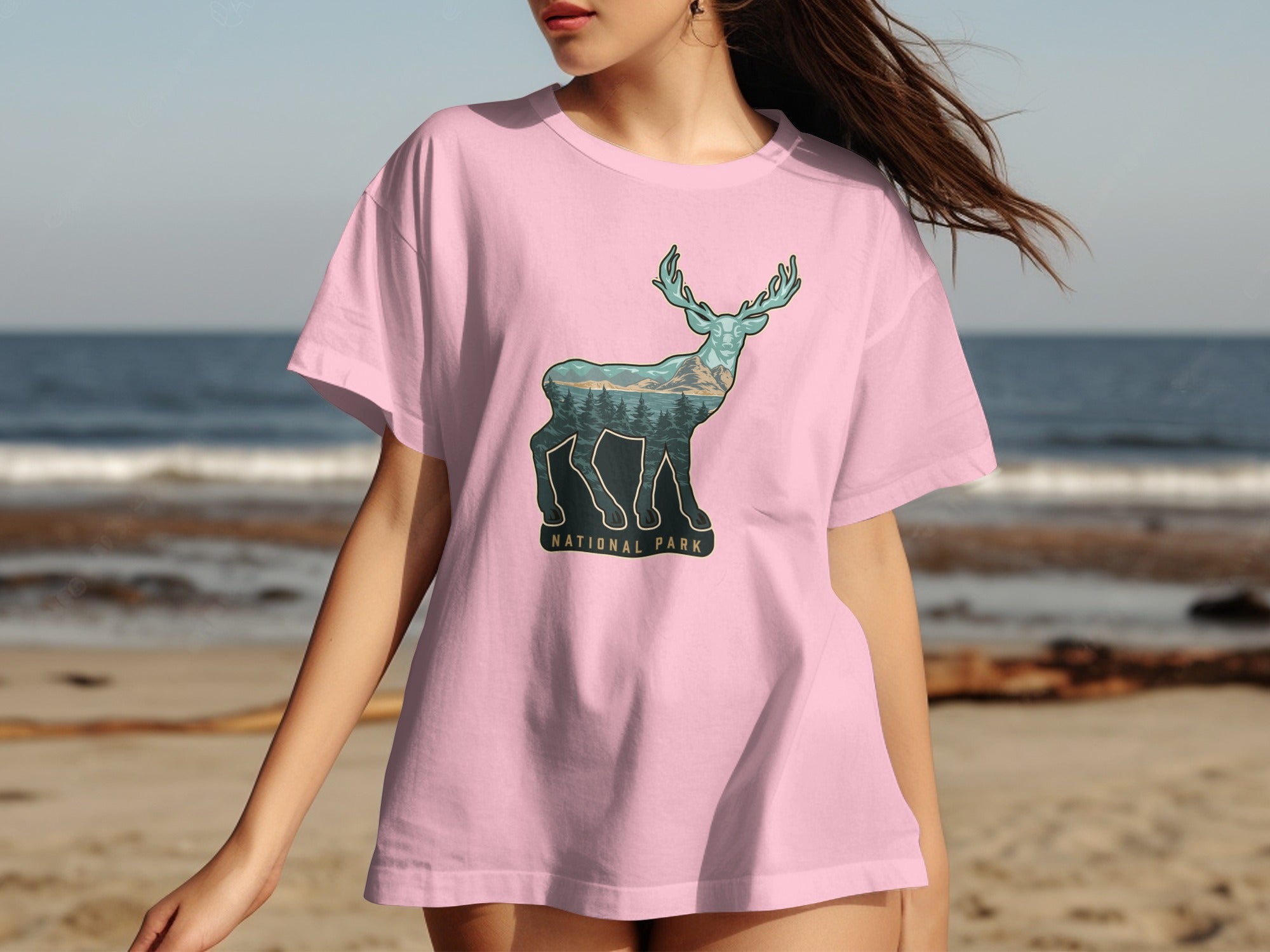 Pink t-shirt with a deer silhouette against a mountain and forest landscape, "National Park" text below.