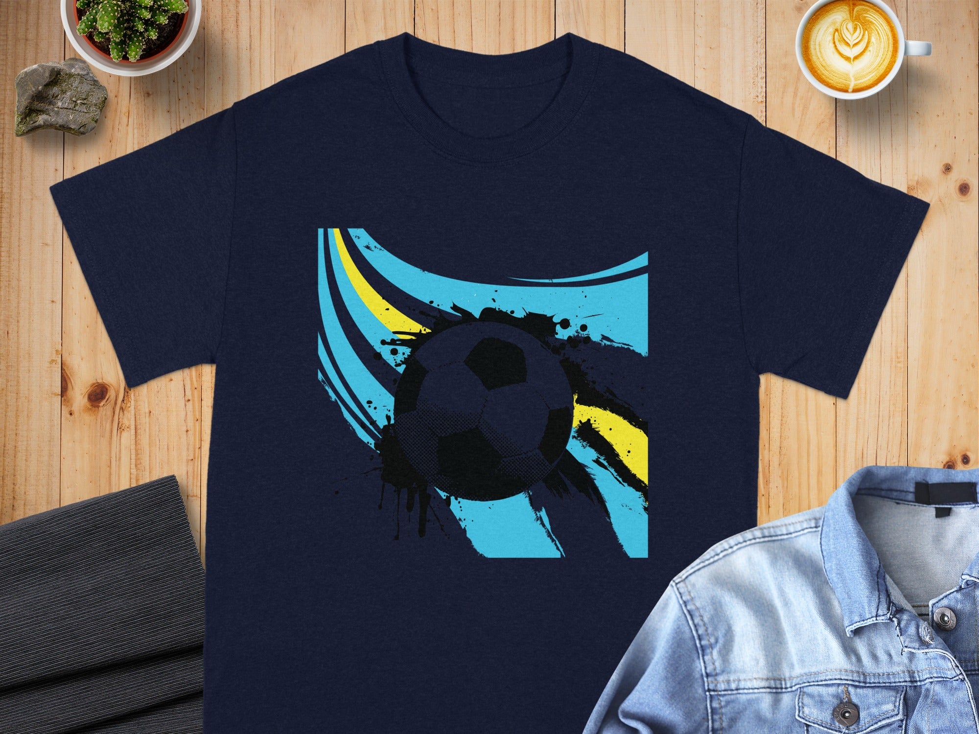 Navy t-shirt with a black and blue soccer ball graphic and abstract yellow lines.