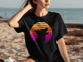 Black t-shirt featuring a silhouette of a dog against a retro sunset graphic.