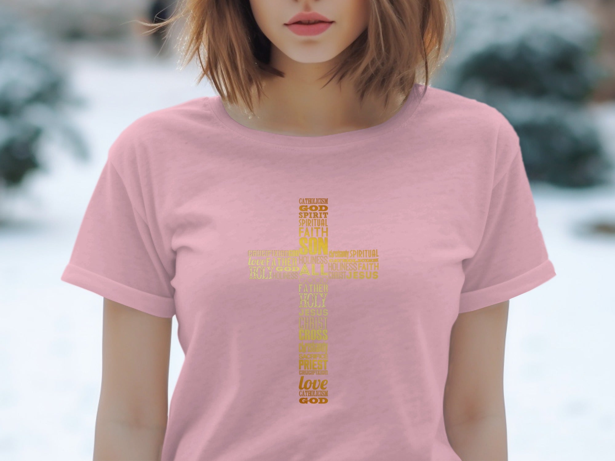 Pink t-shirt with a gold cross made of words like God, Love, Faith, and Jesus.