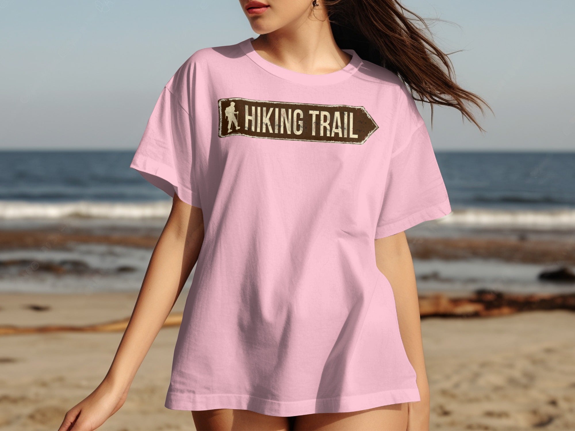 Pink t-shirt with a brown arrow graphic and "HIKING TRAIL" text.