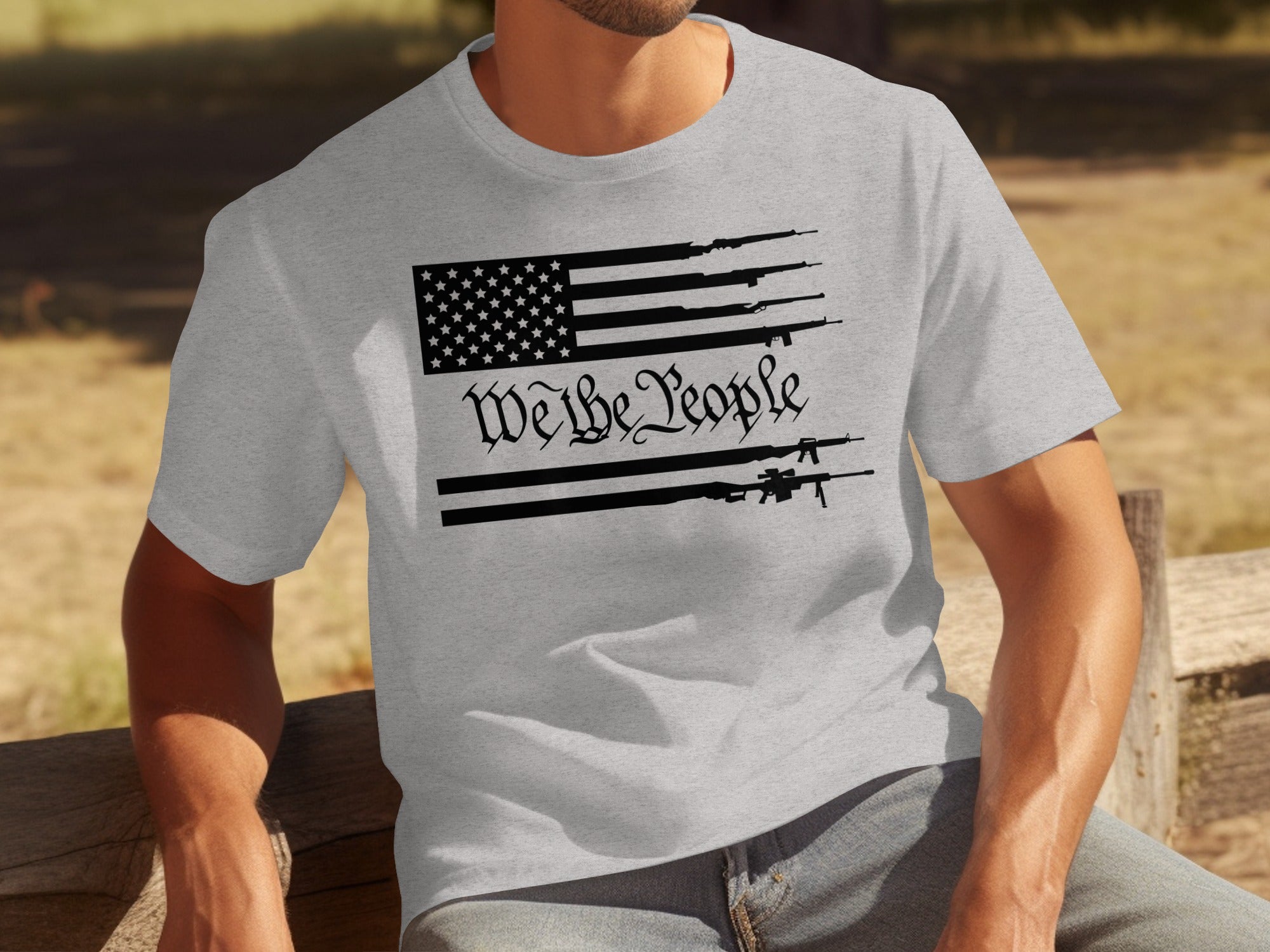 Grey t-shirt with American flag design featuring rifles and "We the People" text.