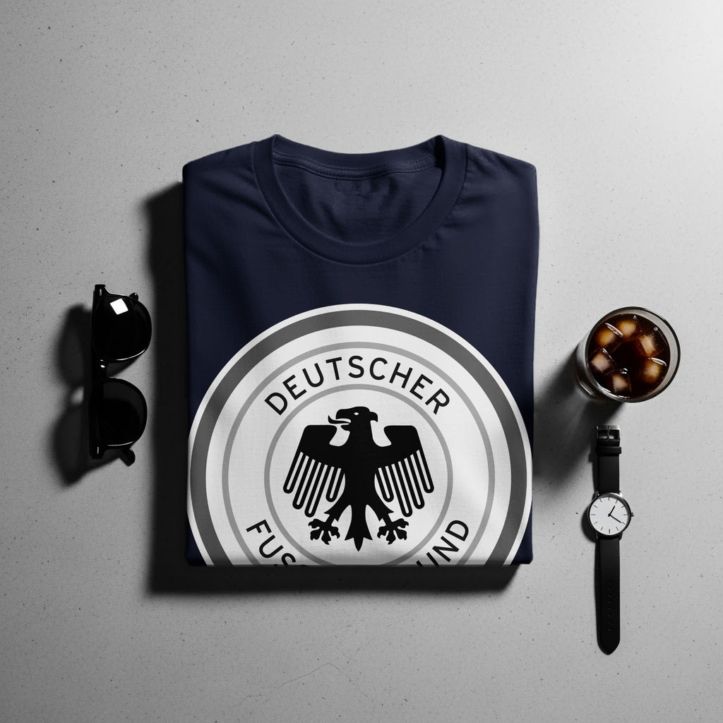 Navy t-shirt with Deutscher Fußball-Bund logo, sunglasses, and a watch.