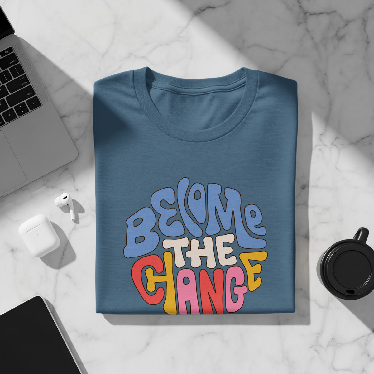 Blue t-shirt with colorful "BECOME THE CHANGE" text in a retro font.