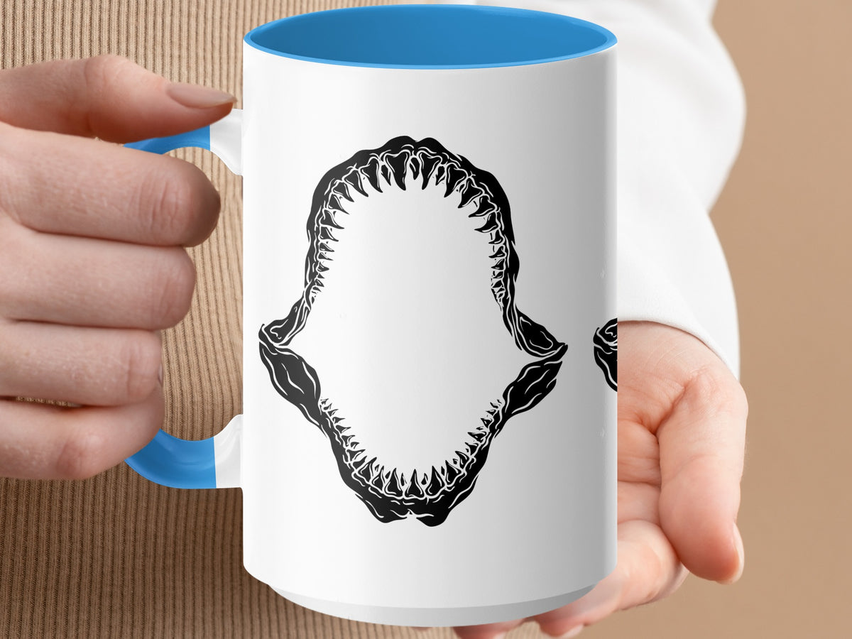 White mug with blue interior and handle, featuring a black shark jaw graphic.