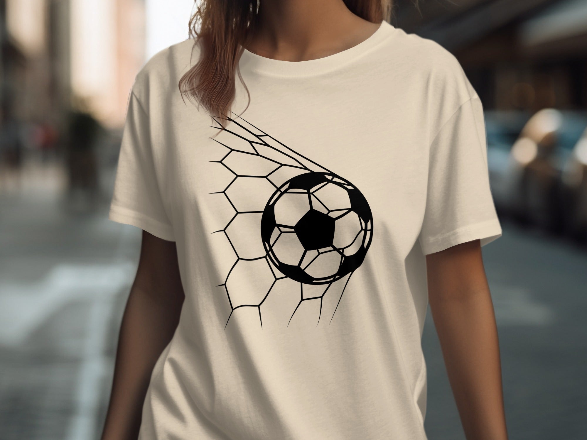 Cream t-shirt with black soccer ball in a net graphic.
