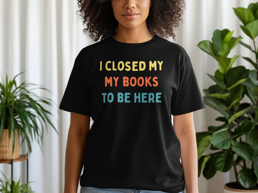 Black t-shirt with yellow, orange, and blue text: I CLOSED MY BOOKS TO BE HERE.