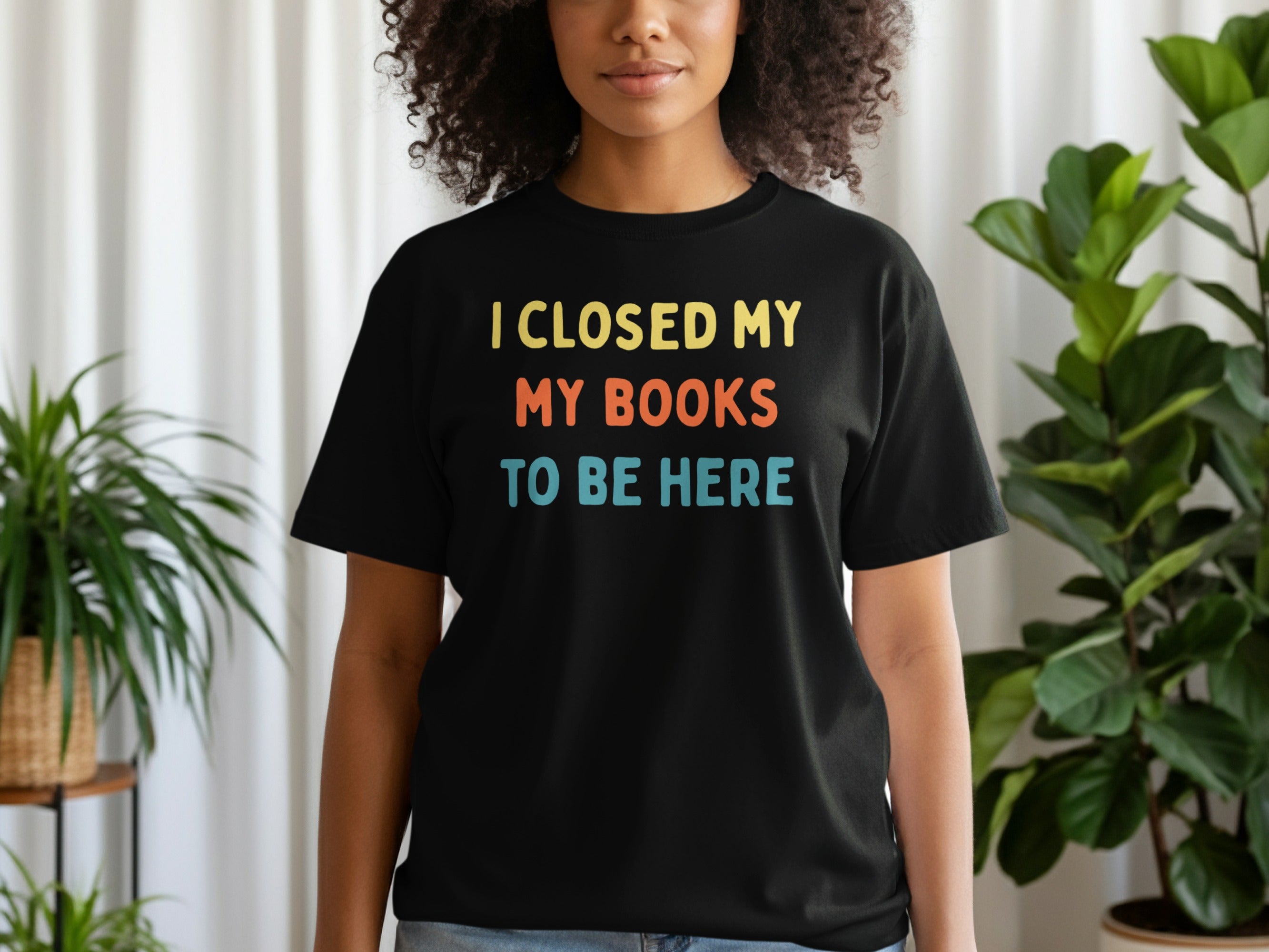 Black t-shirt with yellow, orange, and blue text: I CLOSED MY BOOKS TO BE HERE.