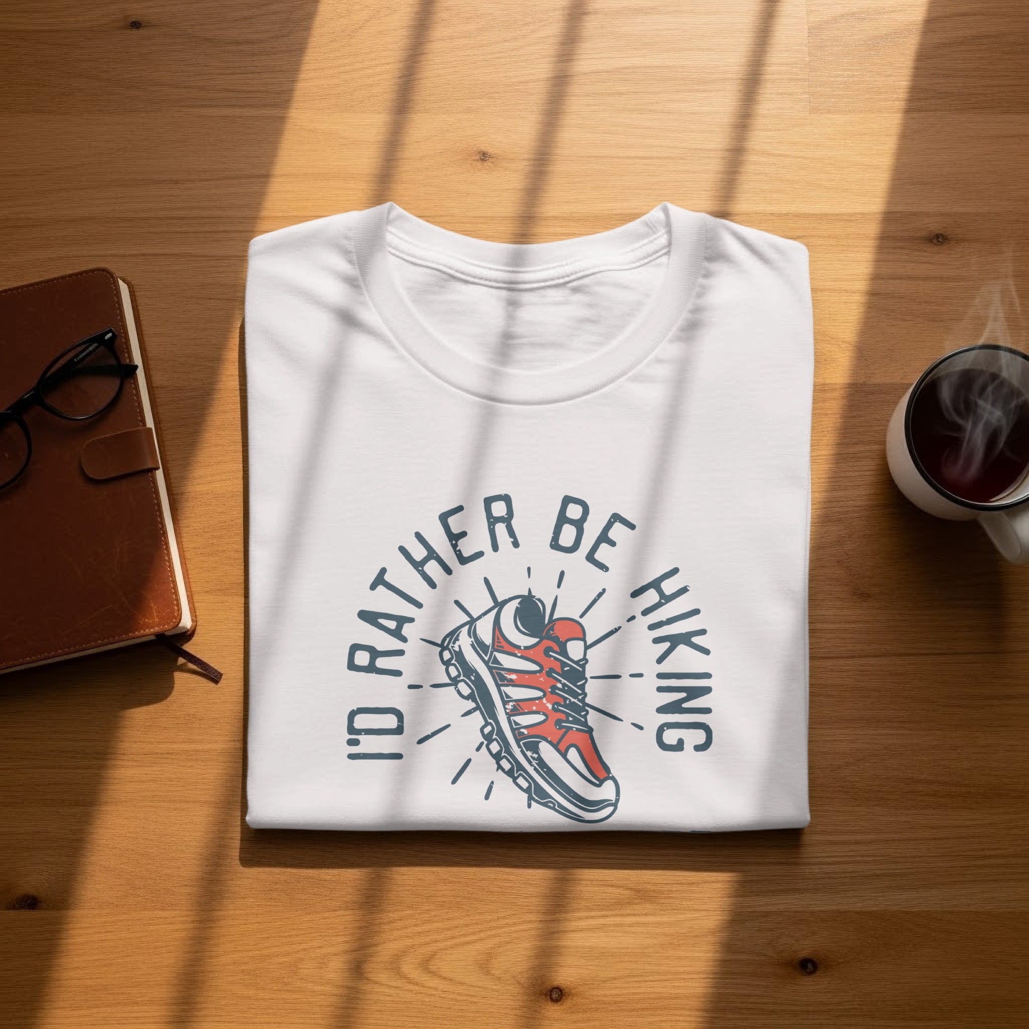 White t-shirt with "I'd Rather Be Hiking" graphic and a hiking shoe.