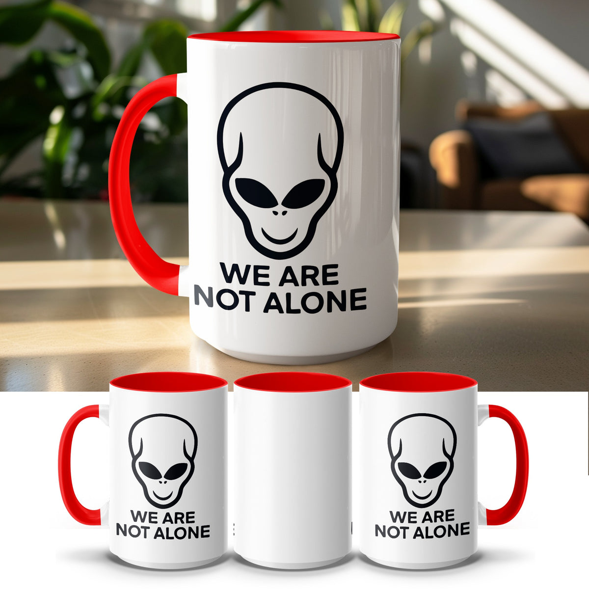 White mug with red rim and handle featuring a black alien head and "WE ARE NOT ALONE" text.