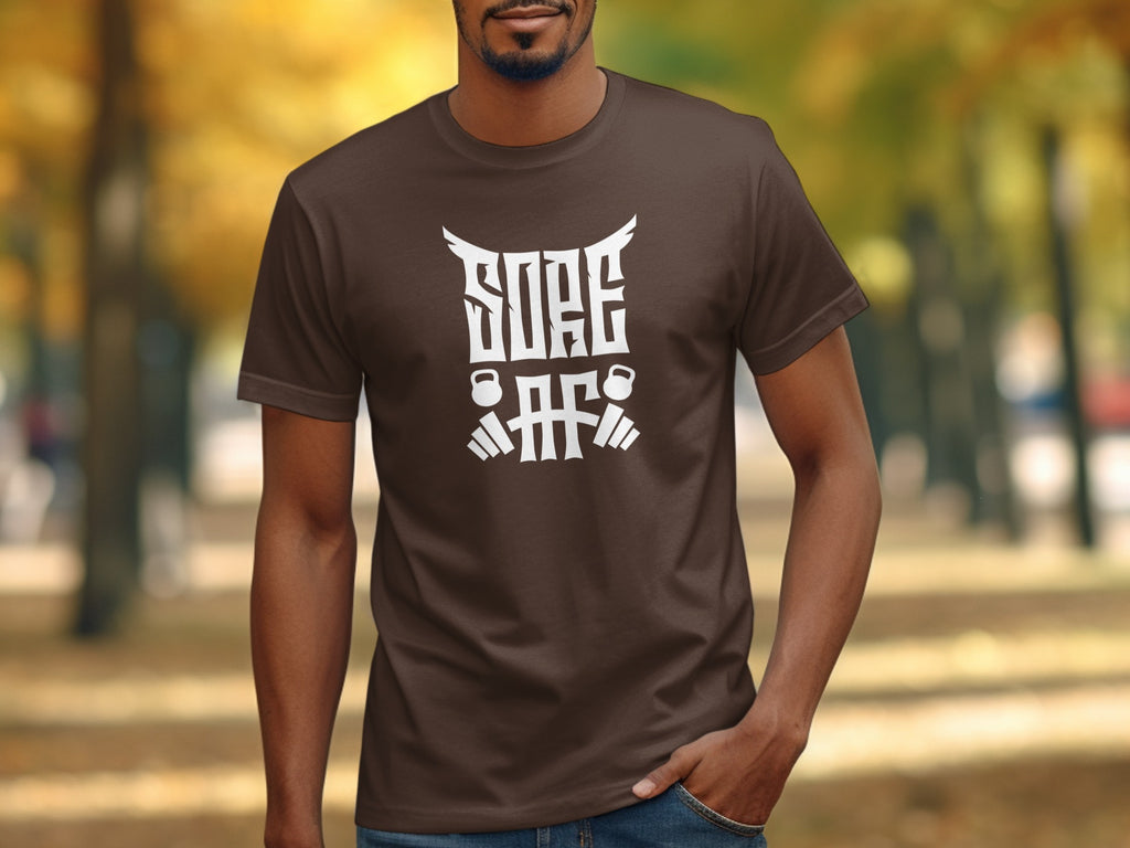Brown t-shirt with white text and graphics of weights on a man.