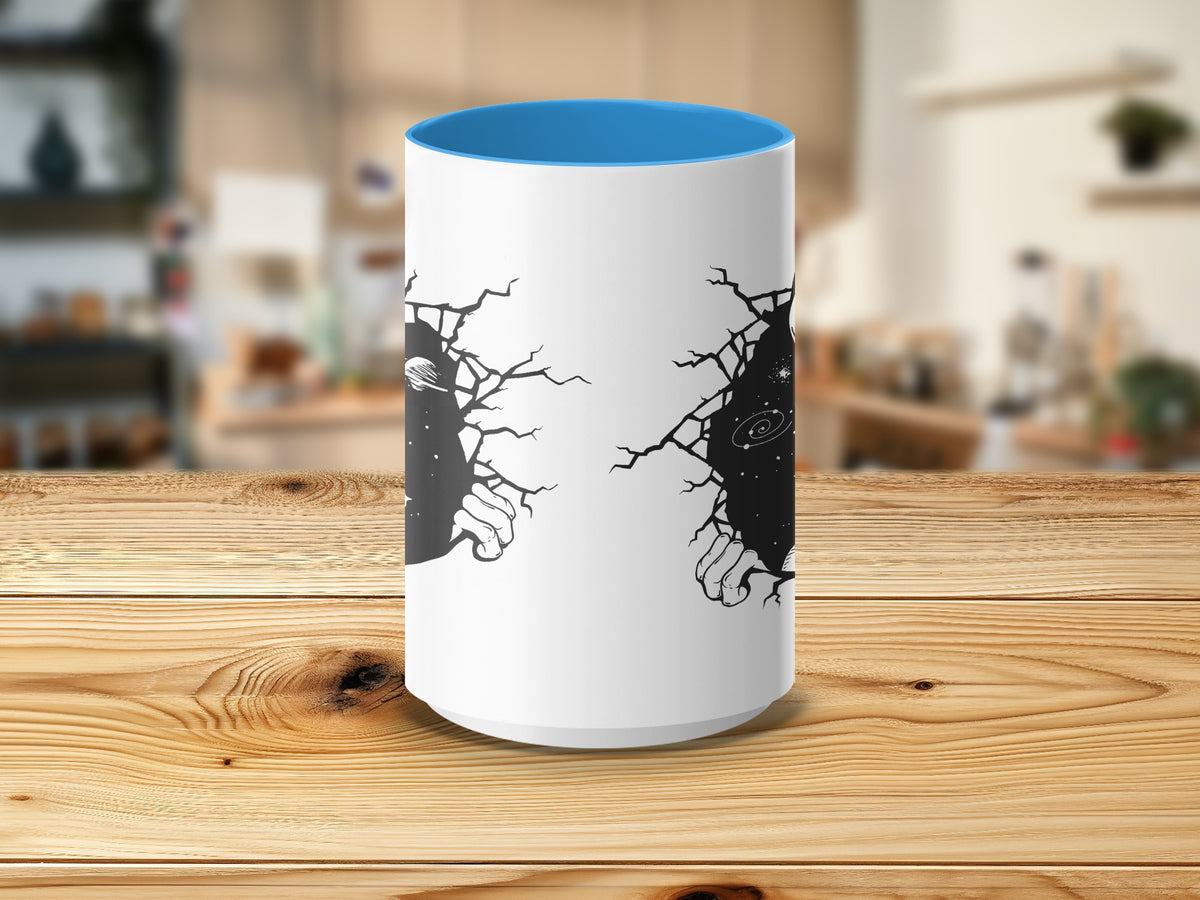 White mug with blue interior, showing cracked space and hands on white surface.